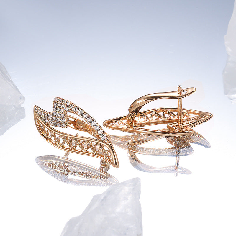 Gold brooches with intricate designs on a light blue background